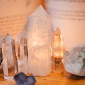 Close-up of various healing crystals on a wooden table with warm lighting