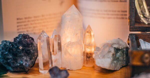 Close-up of various healing crystals on a wooden table with warm lighting